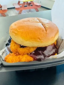 A juicy halal burger with fresh lettuce, tomato, and cheese on a toasted bun at Mo’s in Simsbury.