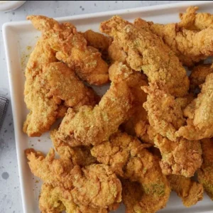 Crispy lemon pepper chicken tenders seasoned with zesty spices on a white serving platter at Mo’s in Simsbury.