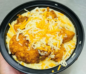 A creamy bowl of macaroni and cheese topped with crispy fried chicken pieces at Mo’s in Simsbury.